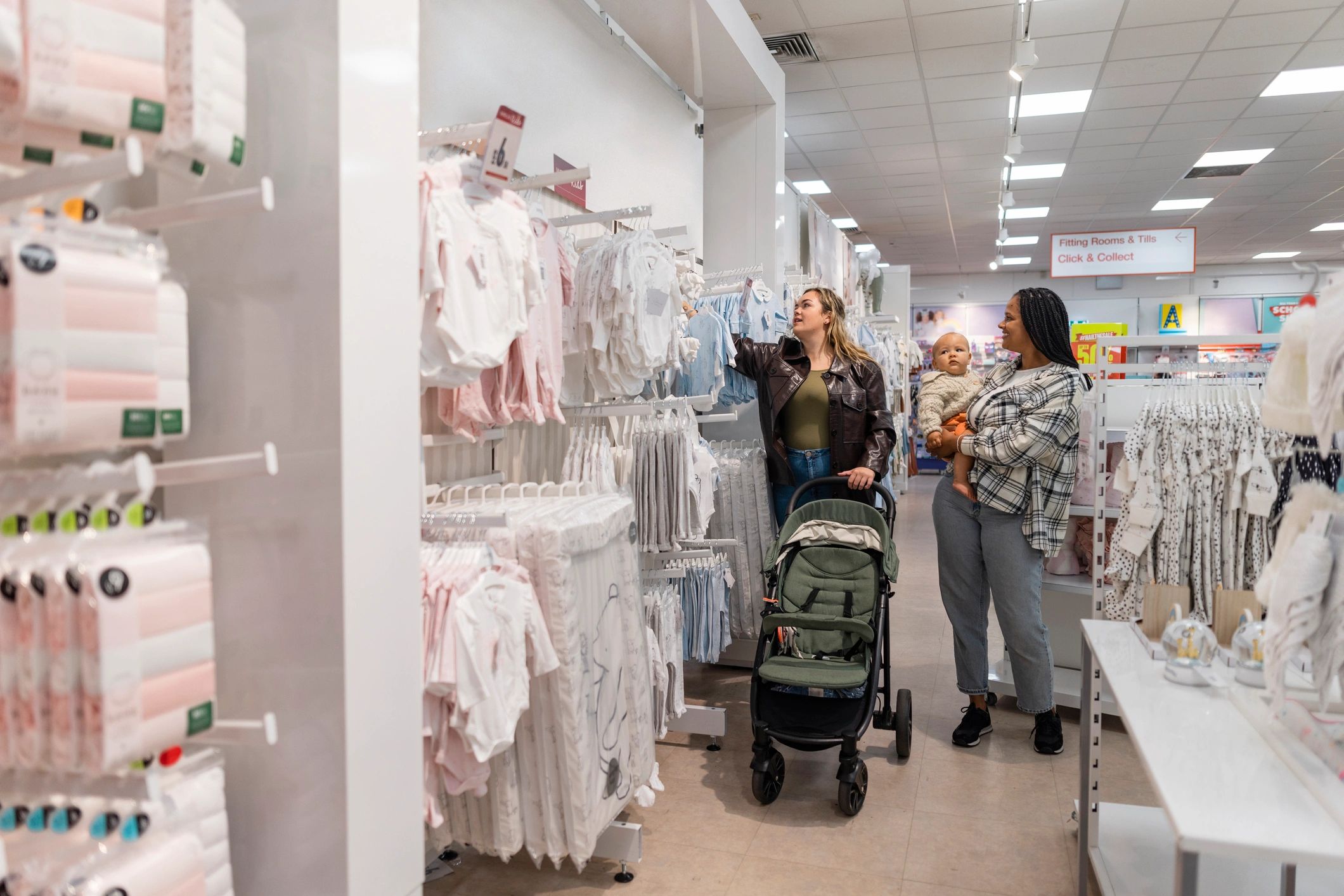 Happy shopper with baby clothing in store