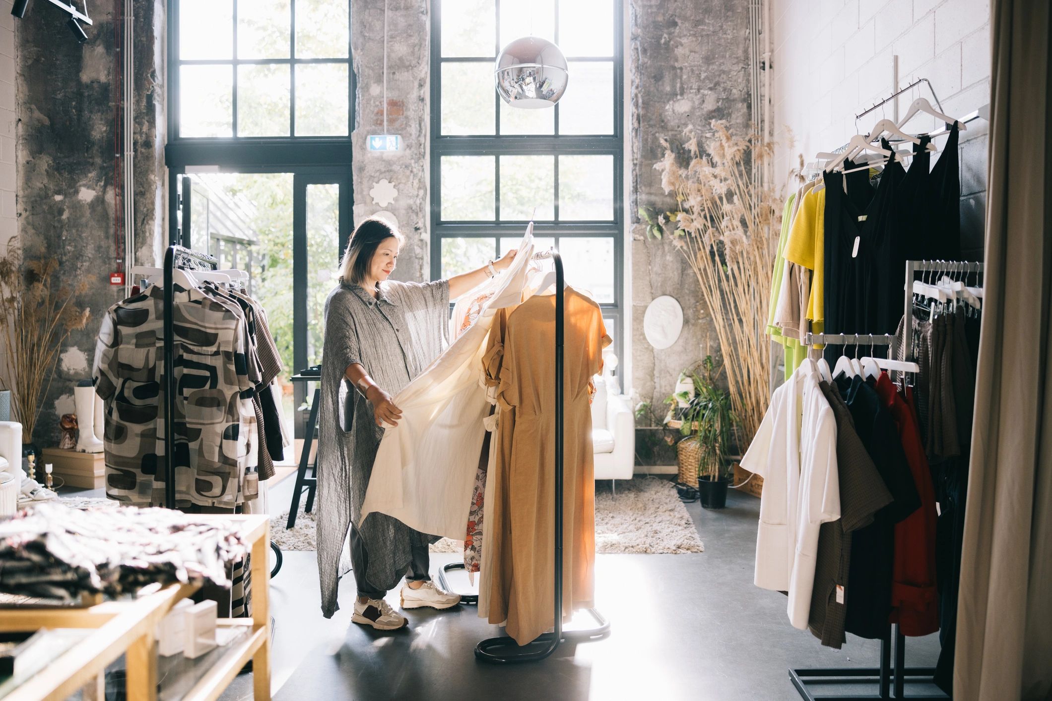 Woman browsing stylish dresses in a modern fashion boutique